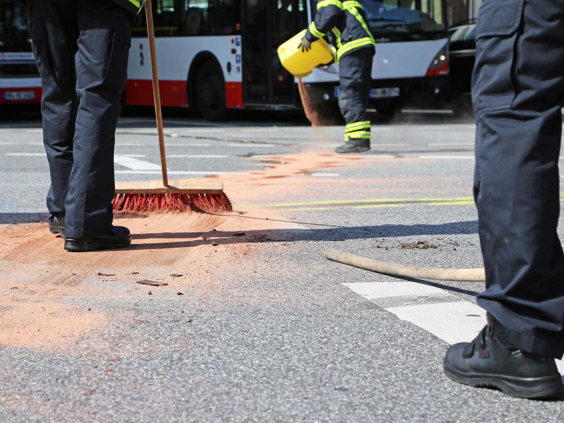 worker spreading a crystalline silica-based mineral absorbent on the road